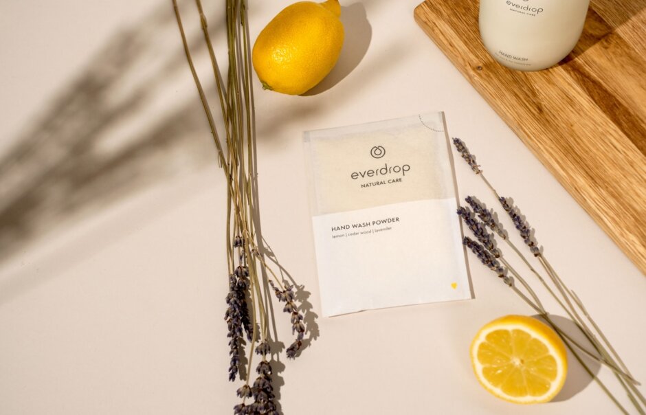 a wooden cutting board topped with a lemon next to a bottle of lotion