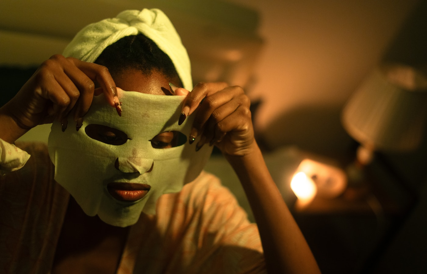 Woman applying a sheet mask to her face
