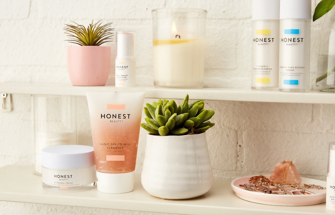 toiletries, plants, and candle on white shelves