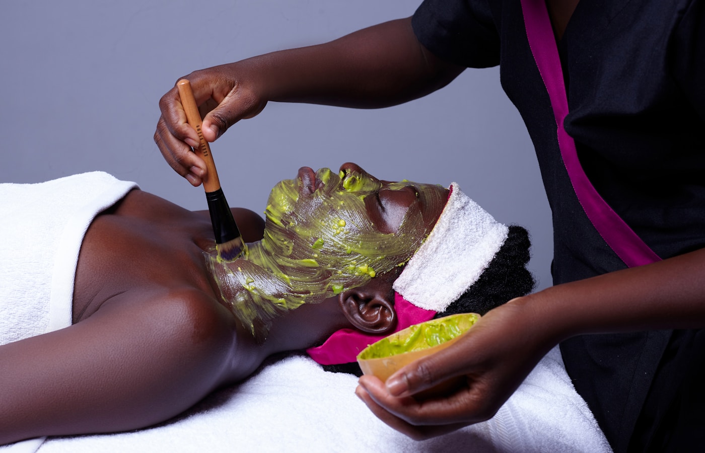 a woman getting a facial mask on her face